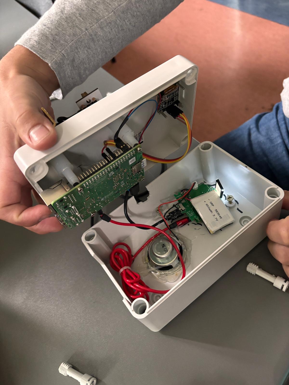 Zbudowane urządzenie: Raspberry Pi z okablowaniem, głośnik i akumulator w białej obudowie